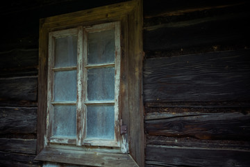 Fototapeta na wymiar Old creepy scary window on wooden house. Halloween, haunted house concept.