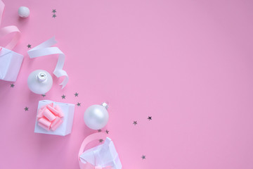Christmas background with decorations and gift boxes on pink background