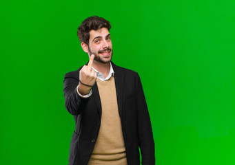 young businessman feeling angry, annoyed, rebellious and aggressive, flipping the middle finger,...
