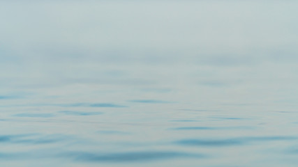 Ripples on surface of blue water with bokeh