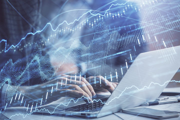 Double exposure of market chart with man working on computer on background. Concept of financial analysis.
