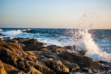 waves breaking in a breeze on a stone coast