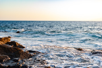 ocean waves cover a stone coast