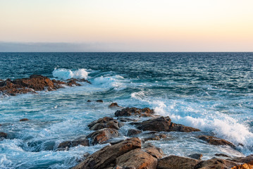 waves crash on stones canary islands, evening ocean