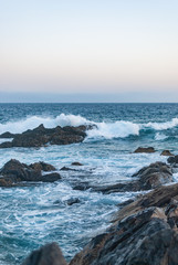 waves crash on stones canary islands, evening ocean