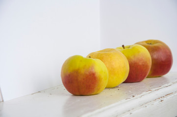 Raw red and green apples on white wooden table