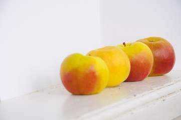 Raw red and green apples on white wooden table