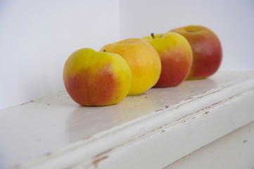 Raw red and green apples on white wooden table