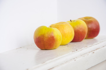 Raw red and green apples on white wooden table