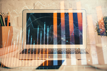 Stock market chart hologram drawn on personal computer background. Double exposure. Concept of investment.