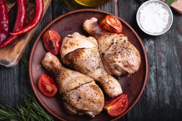 fried chicken drumsticks on a plate, grilled meat, spices and herbs,