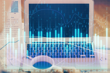 Stock market chart hologram drawn on personal computer background. Double exposure. Concept of investment.