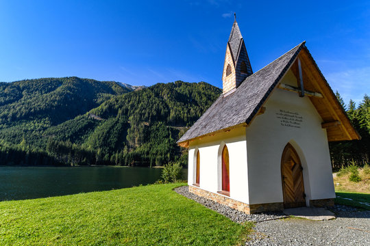 Chapel at Lake "Ingeringsee" surrounded by snowcapped Seckau Alps in Styria, Austria