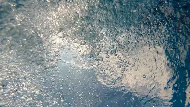 Underwater scene of air bubbles and sunbeams on water surface