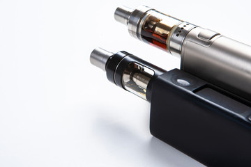 Vape. Vaping. Inventory for Vaper. Two electronic cigarettes are lying on the table. Safe smoking. Fighting a bad habit. Reduce nicotine intake. vape gadgets. Safe cigarette. Smoking e-cigarettes.