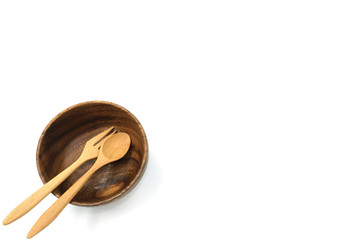 Copy space Wooden circle bowl with fork and spoon in corner isolated on white background