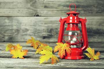 Autumn composition with vintage kerosene lamp and autumn leaves