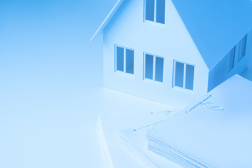 Documents on the desingers desktop.Technical expertise of buildings.Registration of ownership.Inspection of buildings.Building design. Real estate expert career.Paperwork at home.House with an attic