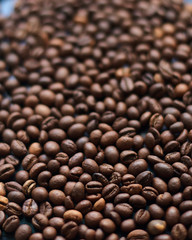 Texture of coffee beans leaving in blurred background. Vertical frame.