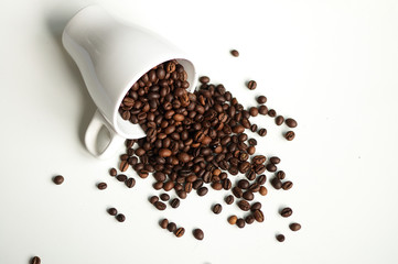 Beautifully scattered grains of coffee on a white background.