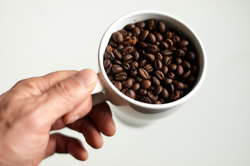 Grains of coffee in a white porcelain bowl.