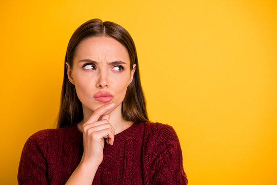 Close up photo of attractive charming pretty cute girl touching her chin while pondering over something being isolated with yellow background