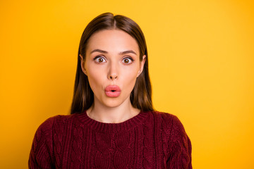 Close up photo of impressed cute frightened girl with her lips pouted by something unexpected while isolated with yellow background