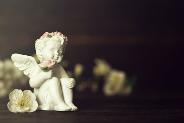 Little guardian angel holding flowers