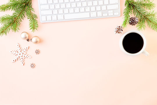 Flat lay christmas home office desk with spruce branche and keyboard, christmas decorations on a color background