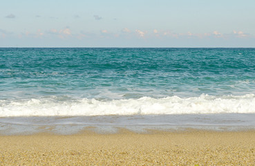 Blue ocean Sea wave with white foam close-up. Sandy beach. Copy space. Selective focus image. Sea beach backdrop. Summer holiday concept.