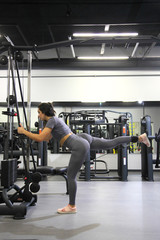 Fototapeta na wymiar Training in the gym for the figure correction. Young woman doing fitness exercises at gym.