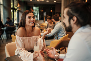 Young happy couple at a date in a cafe