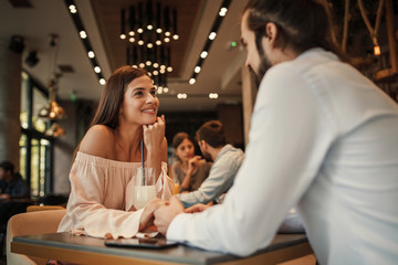 Young happy couple at a date in a cafe