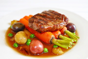 Beef Stew, with Ribeye steak, roasted Peewee potatoes, carrots sauteed in EVOO and sea salt, caramelized pearl onions, and steamed English green peas, with a reduction of beef broth and demiglace 