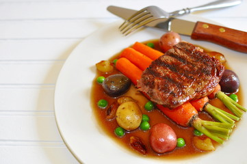 Beef Stew, with Ribeye steak, roasted Peewee potatoes, carrots sauteed in EVOO and sea salt, caramelized pearl onions, and steamed English green peas, with a reduction of beef broth and demiglace 