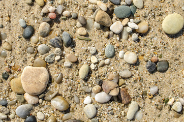 Pebble beach. Small colored sea stones close-up. Multicolor seabed. Selective focus image, copy space. Sea beach backdrop. Summer holiday concept.