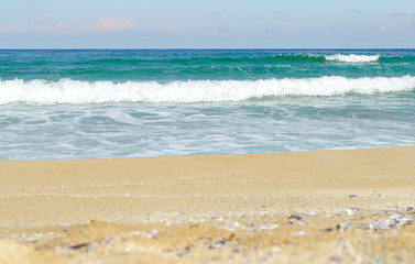 Blue ocean Sea wave with white foam close-up. Sandy beach. Copy space. Selective focus image. Sea beach backdrop. Summer holiday concept.