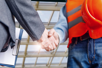 The engineer and businessman shaking hands .