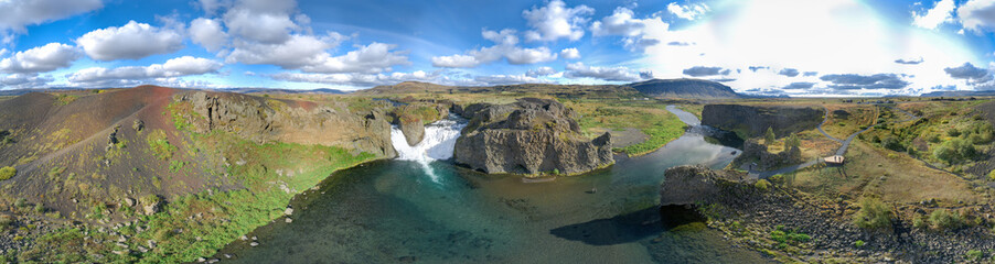 360 degrees Icelandic aerial panorama landscape. Panorama of the Hjalparfoss waterfall and the lagoon on a sunny day.