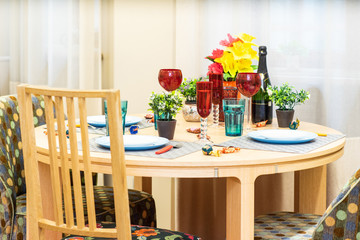 Served table in modern studio interior. Wine glasses.