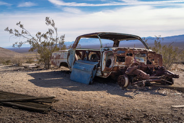 Obraz na płótnie Canvas Old rusted wreck car at Ghost town Rhyolite near Beatty at Hwy 374, Nevada, USA