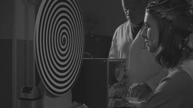 Scientist hypnotizing a woman in a scientific lab