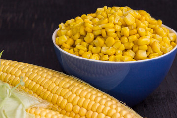 Boiled corn in a bowl. Raw Corn with Green Leaves.
