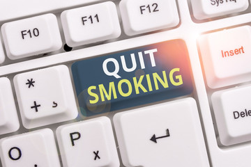 Conceptual hand writing showing Quit Smoking. Concept meaning process of discontinuing tobacco smoking or cessation White pc keyboard with note paper above the white background