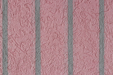 Fragment of a stucco wall of cold shades of gray and pink with l
