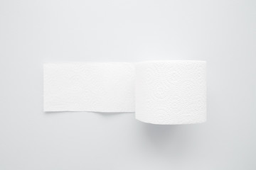 Soft, white toilet paper roll on light gray background. Hygiene concept.