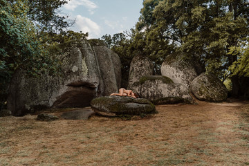 Nude woman lying on a rock at Beglik Tash prehistoric rock sanctuary, Bulgaria