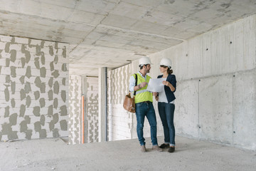Male architect and female, manager talking at construction site