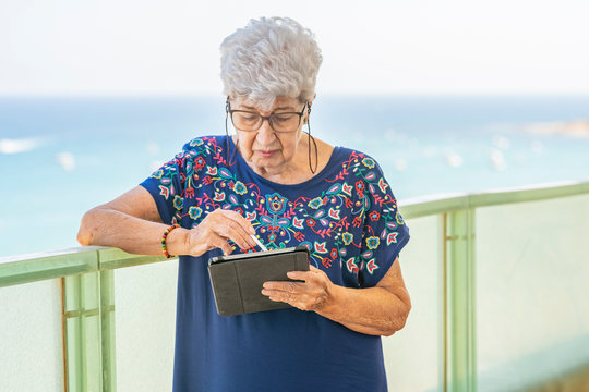 Senior woman using a tablet on a terrace
