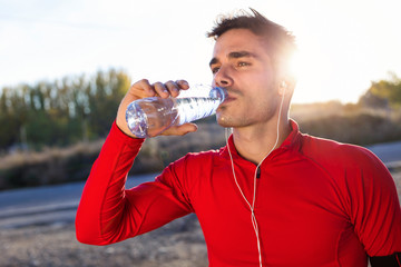 Young jogger drinking from a water bottle
